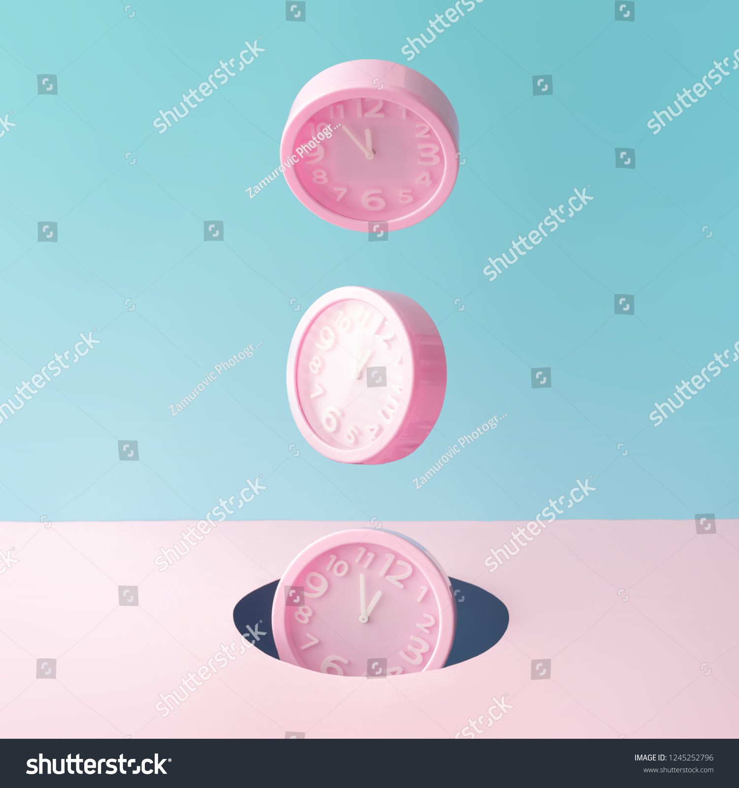 Pastel pink wall clocks on blue backdrop falling down. Time concept. Minimal composition. #1245252796