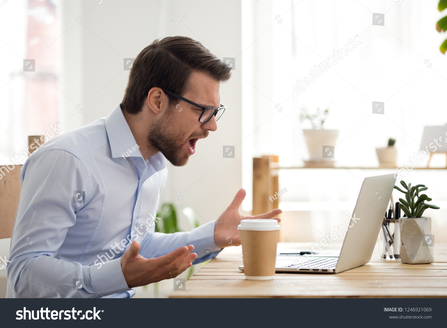 Mad male worker lose temper scream loudly having computer problems or virus attack, furious man shout experience laptop breakdown or data loss while working, angry employee get error message on pc #1246921069