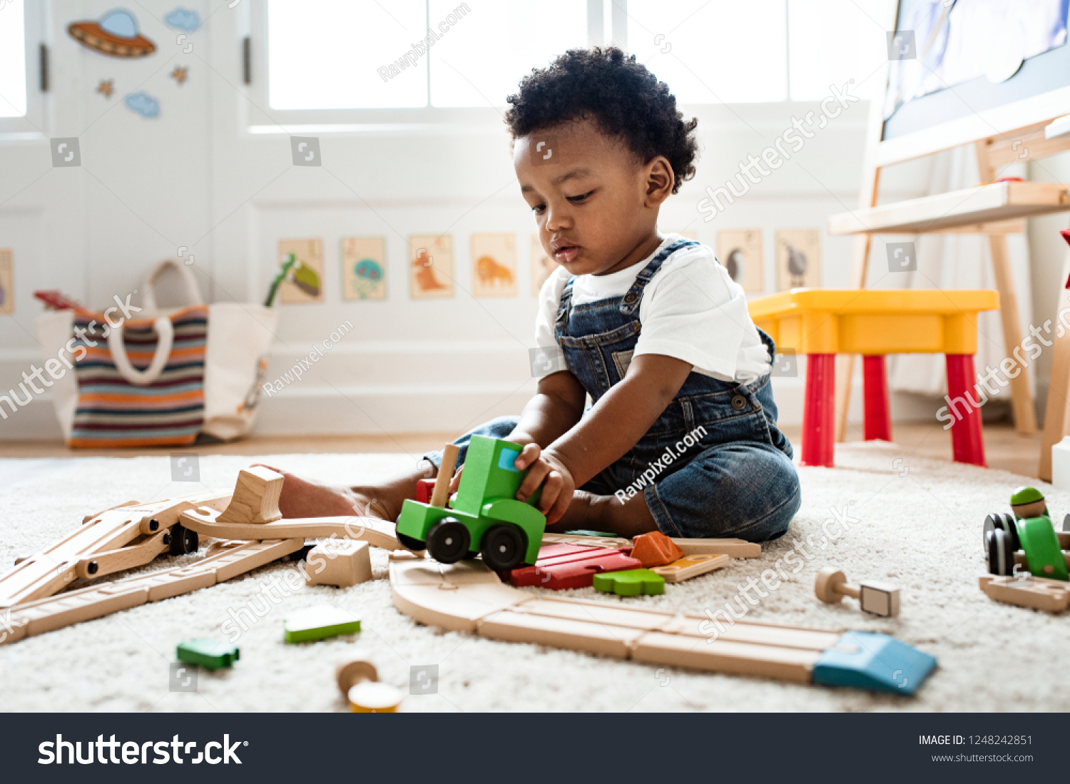 Cute little boy playing with a railroad train toy #1248242851