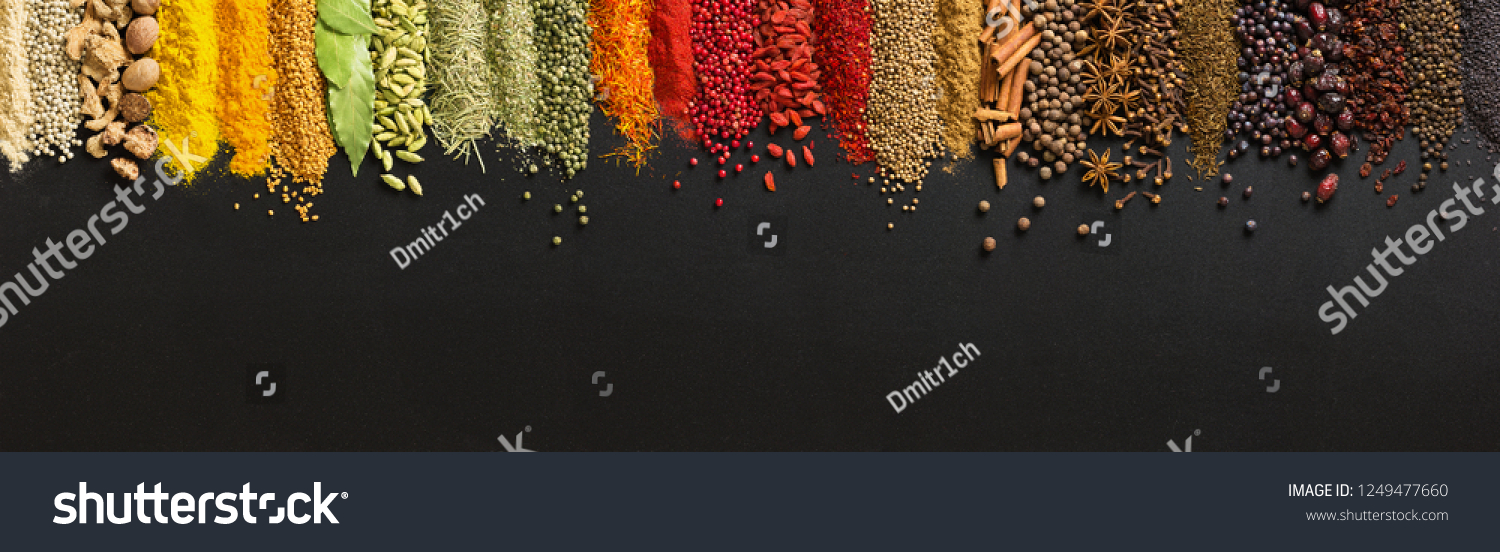 Wide variety spices and herbs on background of black table, with empty space for text or label. #1249477660