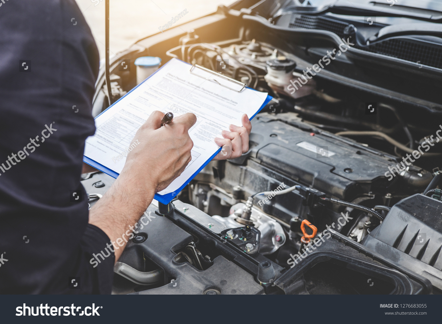 Services car engine machine concept, Automobile mechanic repairman checking a car engine with inspecting writing to the clipboard the checklist for repair machine, car service and maintenance. #1276683055