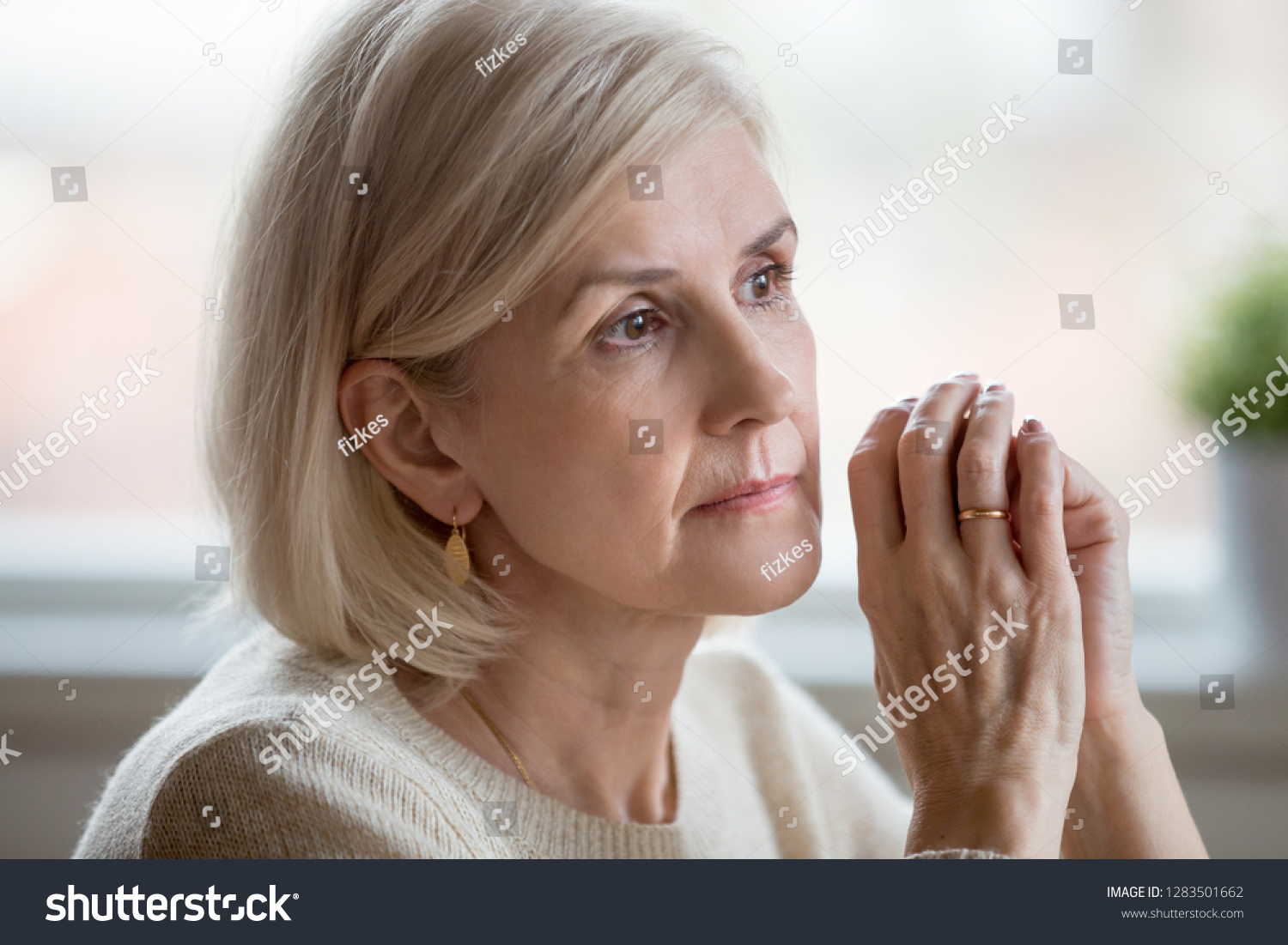 Close up portrait of beautiful sad woman folding hands together near her face, thinking about life. Aging is period of physical decline and senile dementia, mental disorders emotional problems concept #1283501662