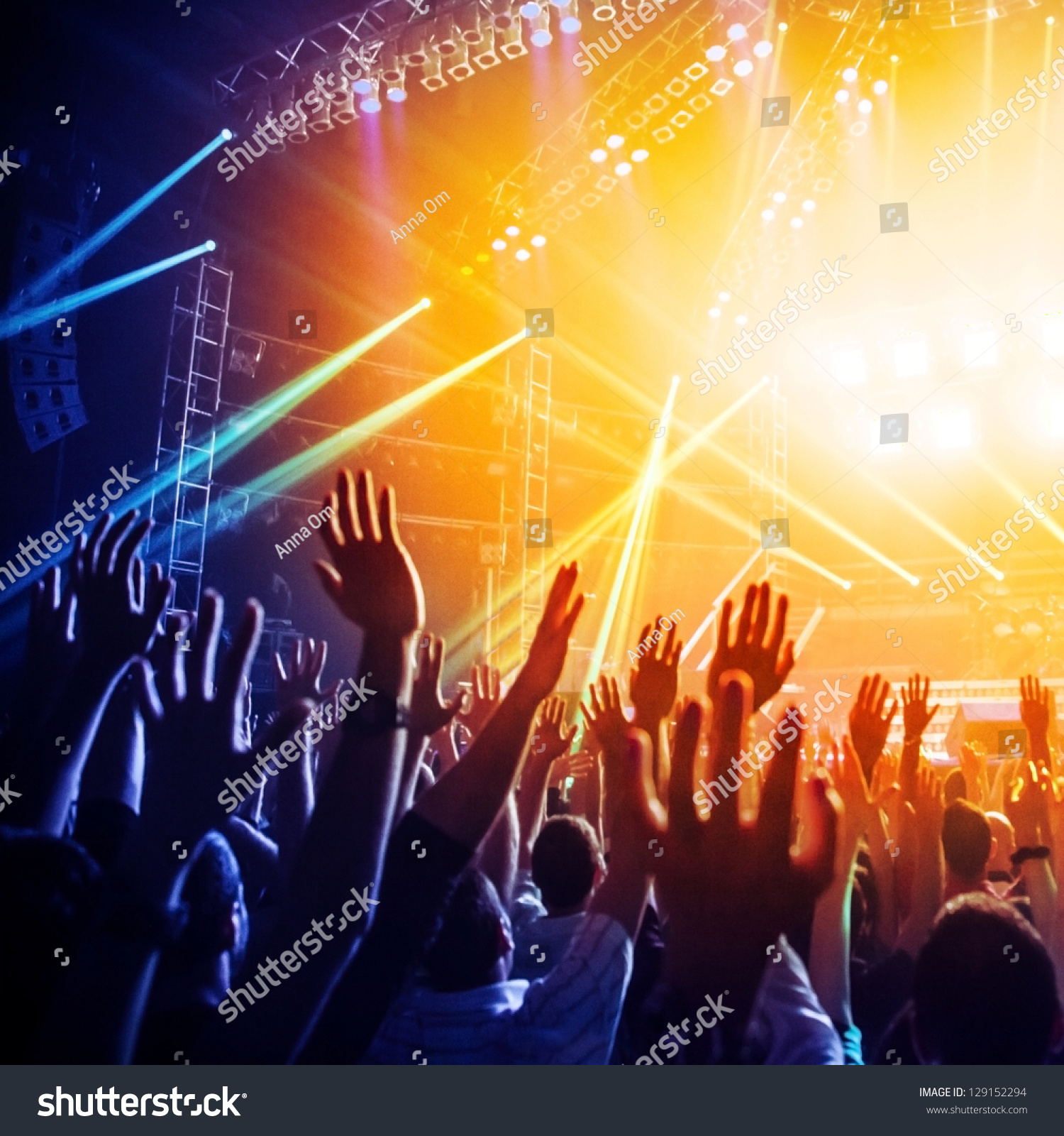Photo of many people enjoying rock concert, crowd with raised up hands dancing in nightclub, audience applauding to musician band, night entertainment, music festival, happy youth, luxury party #129152294