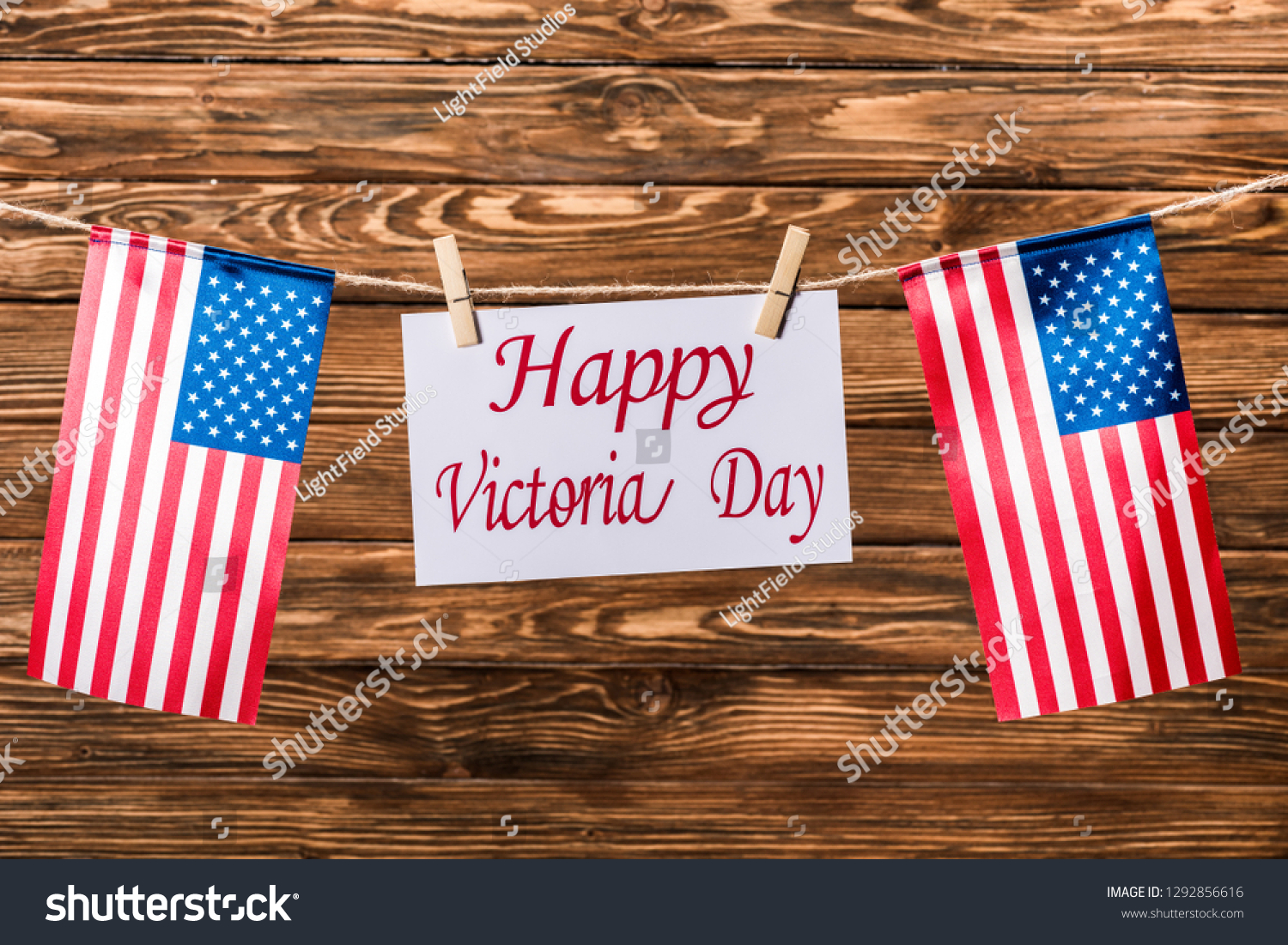 top view of american flags and card with 'happy victoria day' lettering on wooden background #1292856616