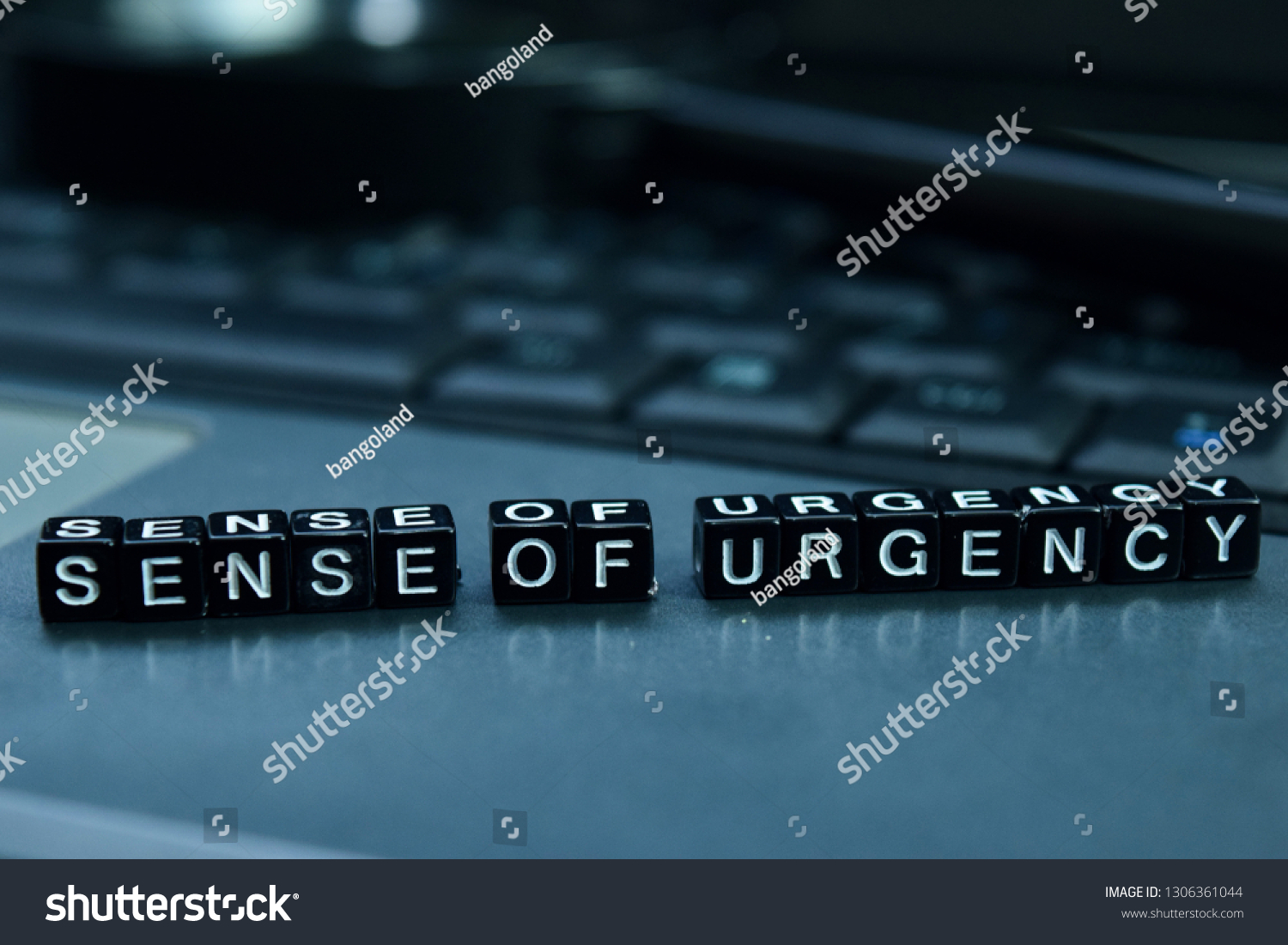 Sense of urgency text wooden blocks in laptop background. Business and technology concept #1306361044