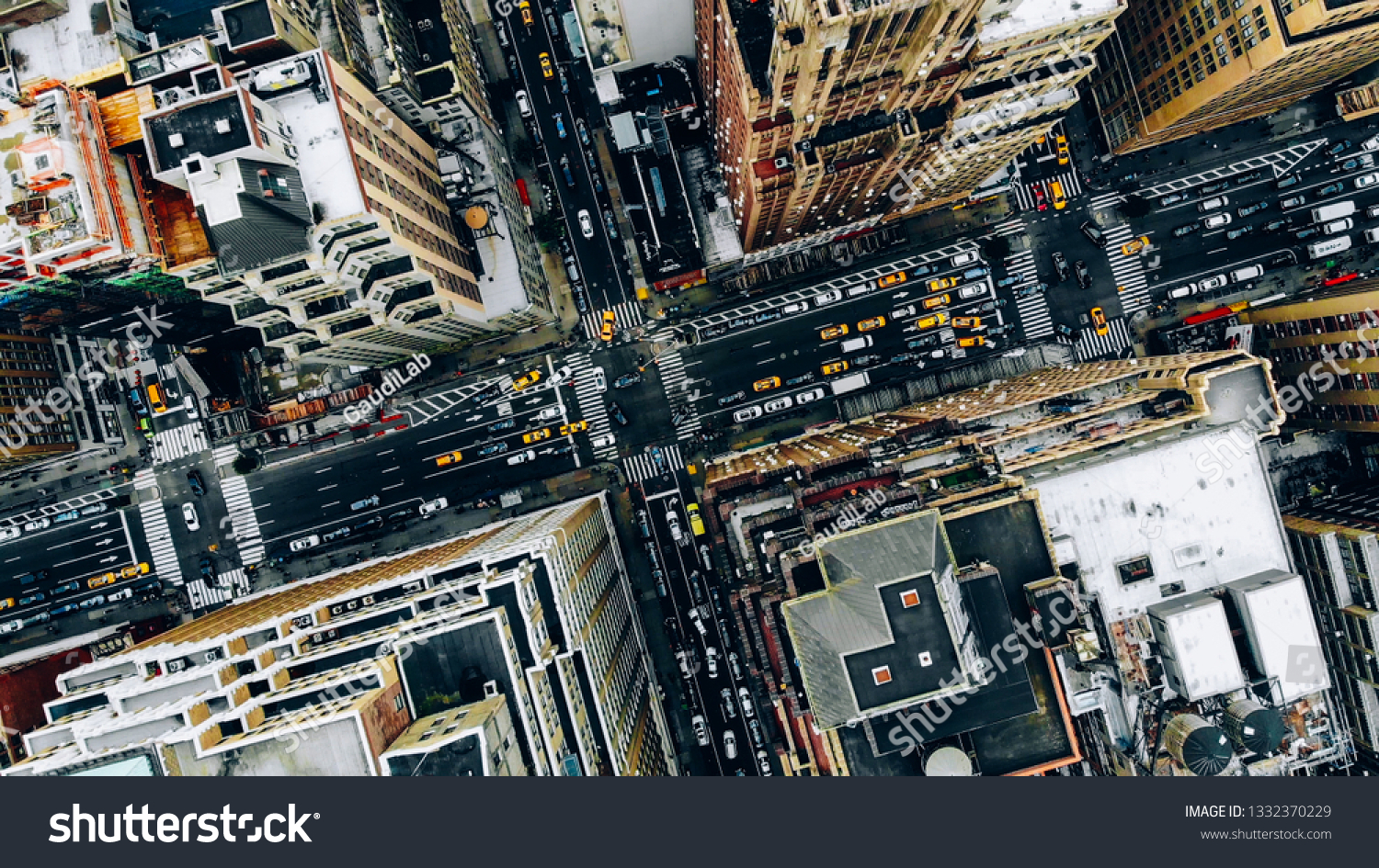Aerial view of New York downtown building roofs. Bird's eye view from helicopter of cityscape metropolis infrastructure, traffic cars, yellow cabs moving on city streets and crossing district avenues #1332370229