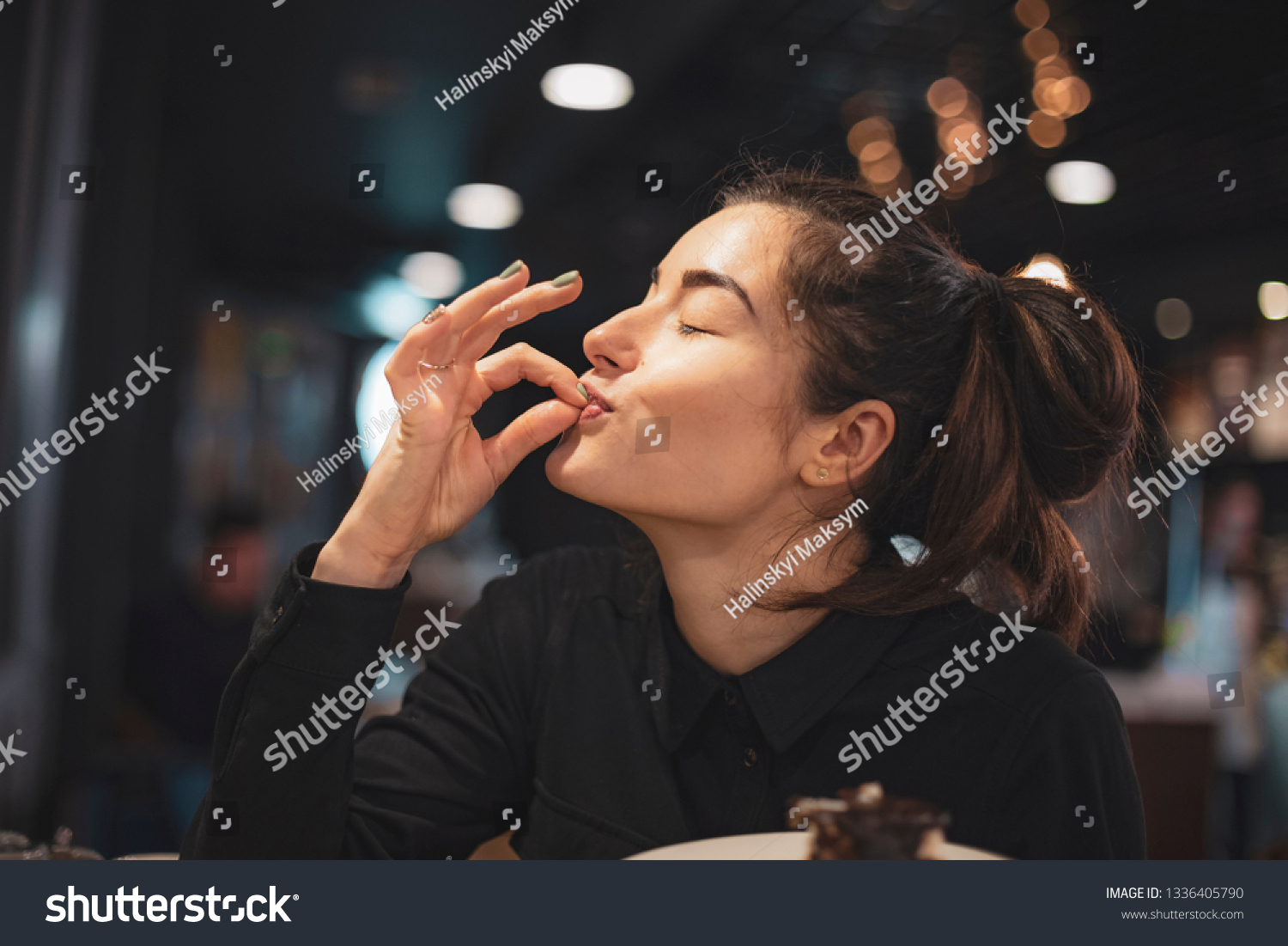 Closeup of woman eating chocolate cake in a cafe. selective focus, noise effect #1336405790