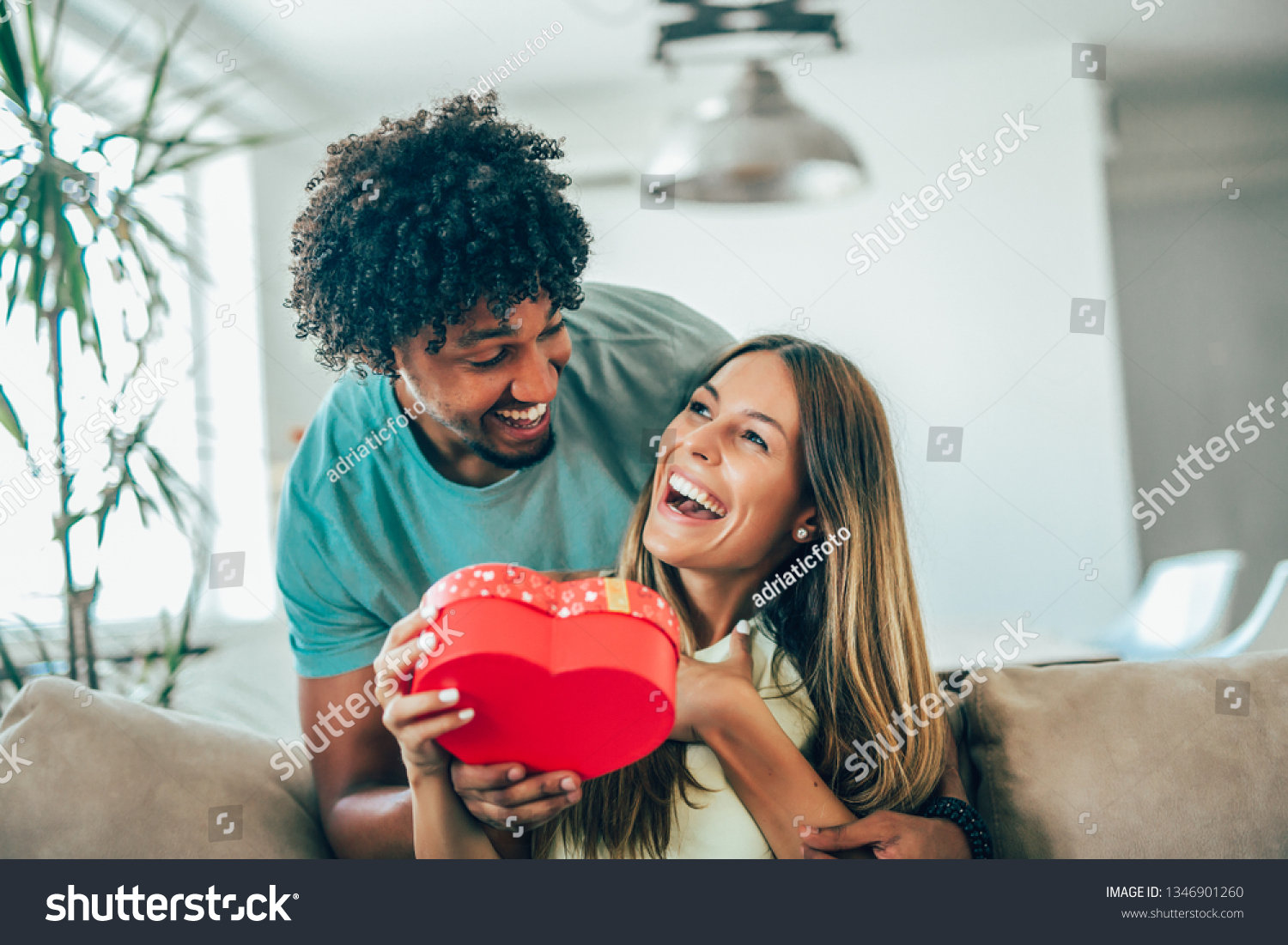 Man giving a surprise gift to woman at home #1346901260