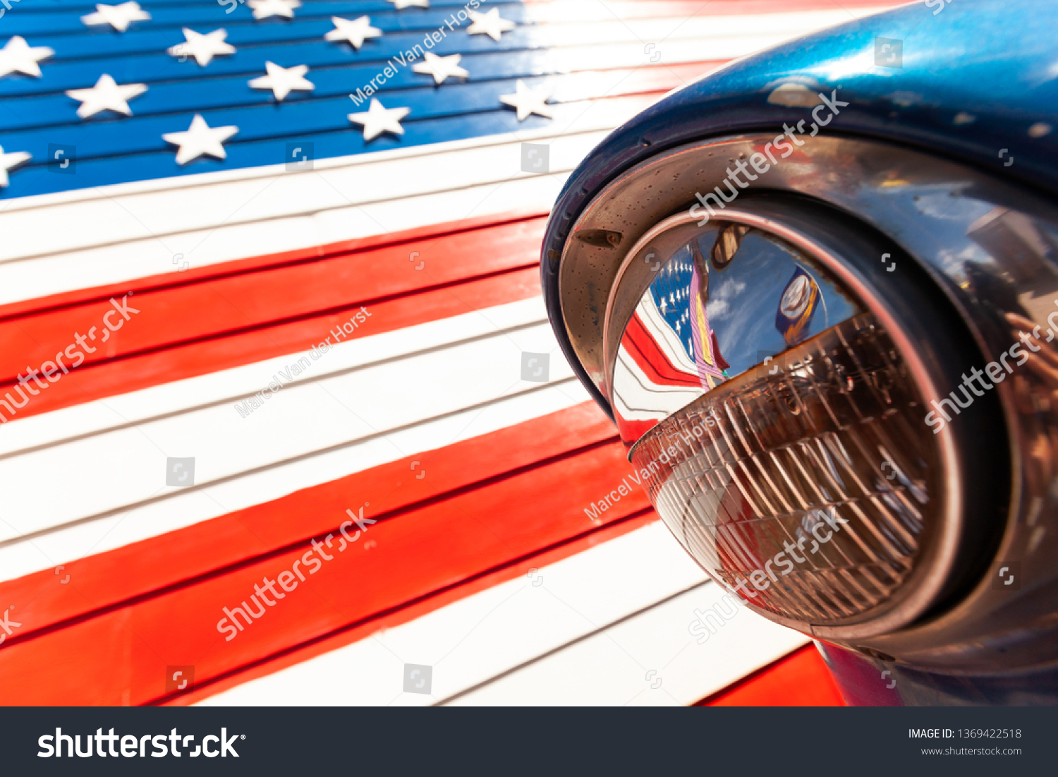 Reflection of American flag in the headlight of a classic car on route 66 america's iconic highway #1369422518