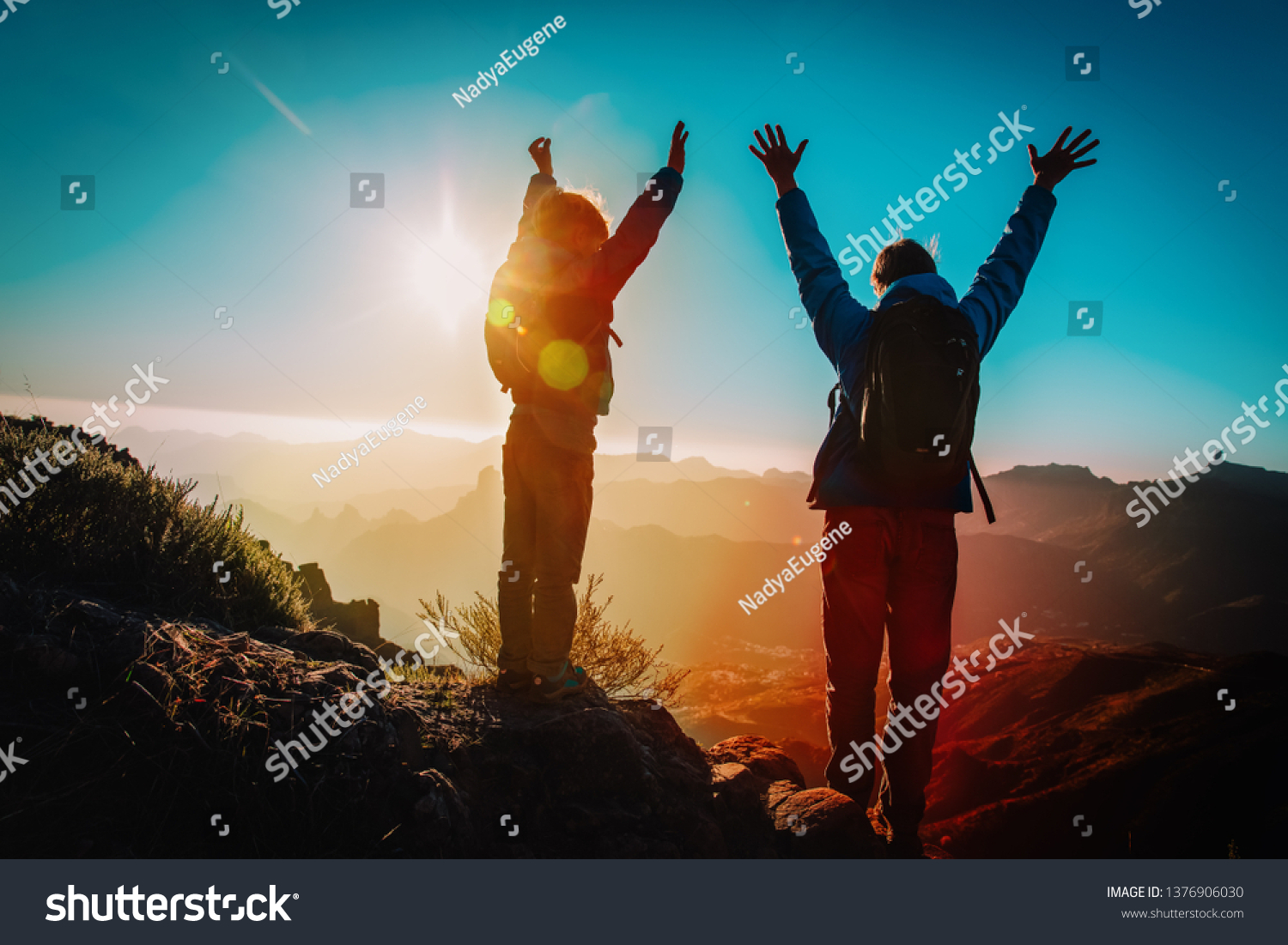 Father and son travel in sunset mountains, family hiking in nature #1376906030