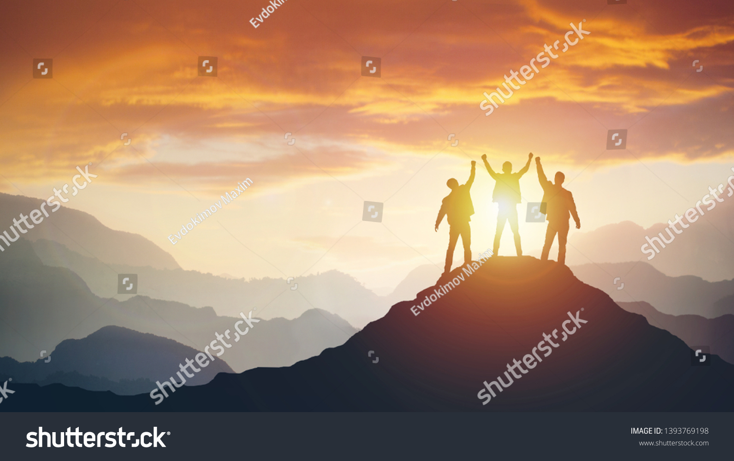 Group of peoples on mountains top in winner pose. Leadership Concept #1393769198