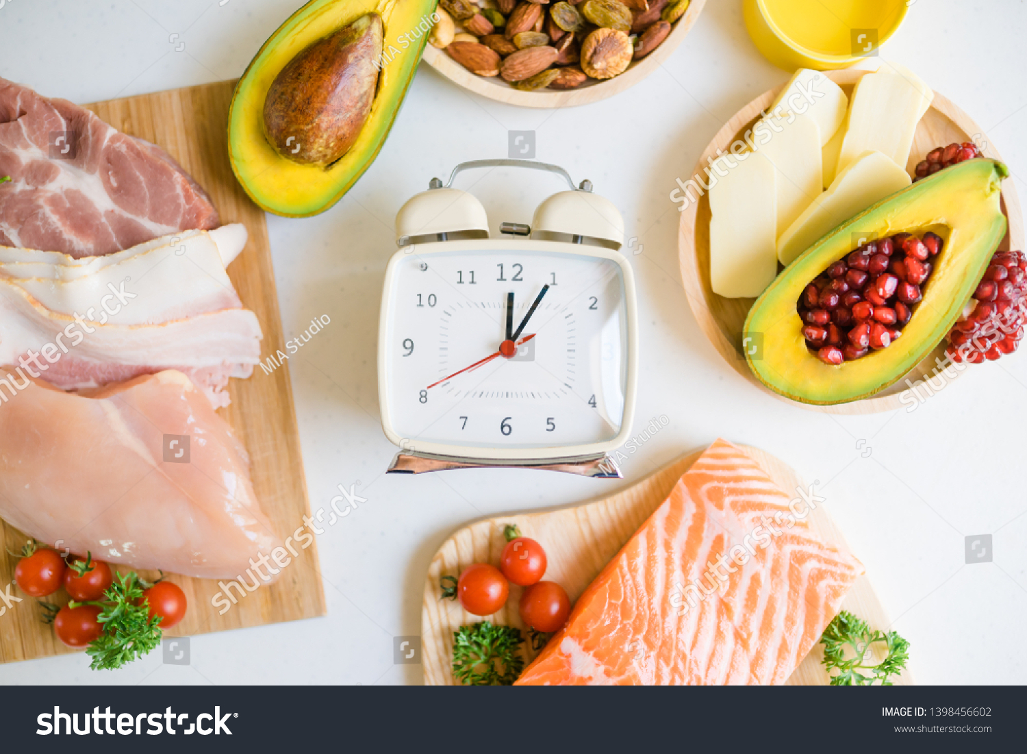  Intermittent fasting and Healthy food. Concept.Alarm clock and Keto diet food ingredients on white table.Ketogenic mean Low carb and High fat. #1398456602
