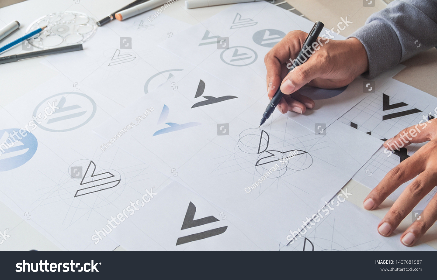 Graphic designer drawing sketch design creative Ideas draft Logo product trademark label brand artwork. Graphic designer studio Concept. #1407681587