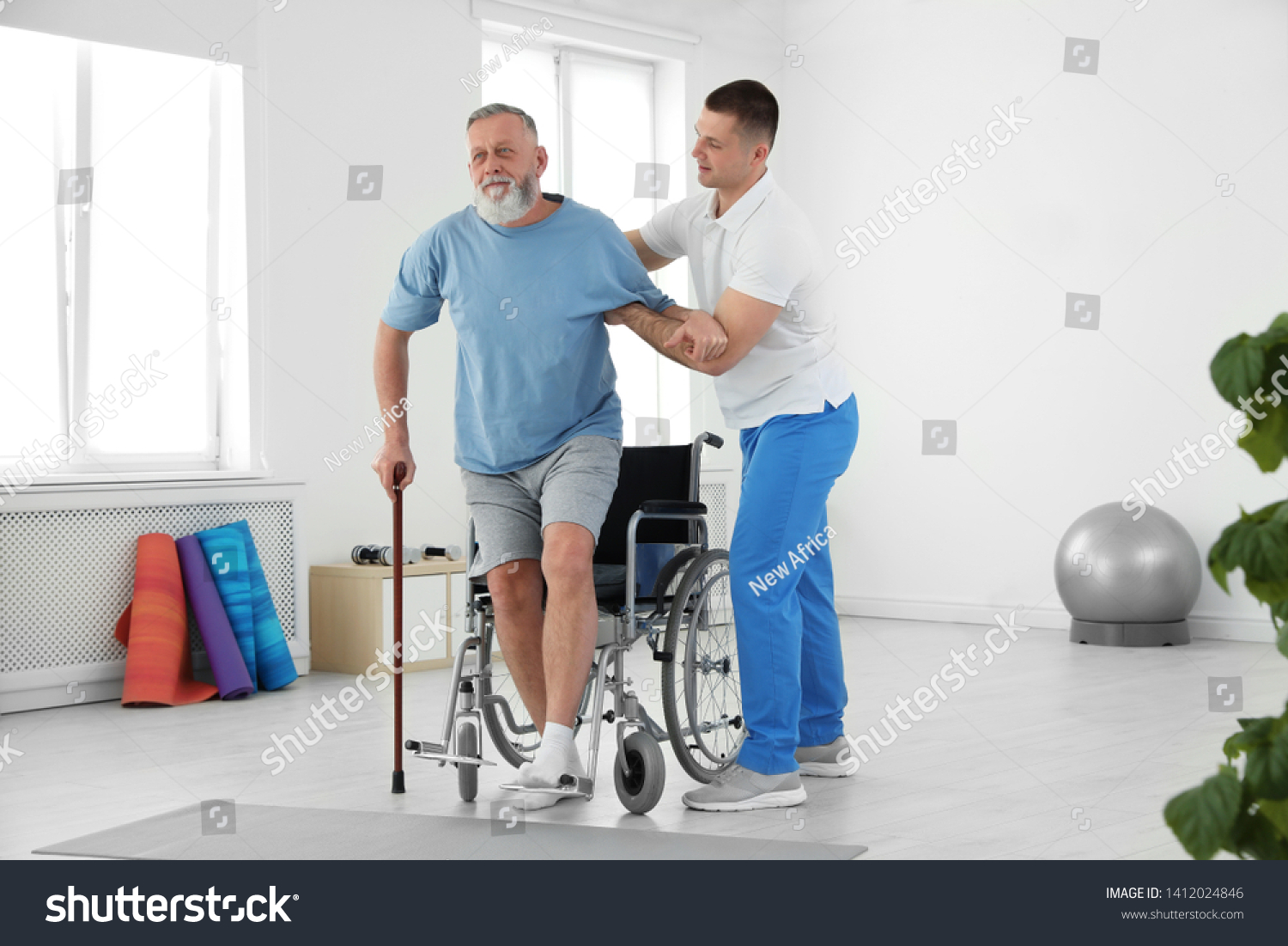 Professional physiotherapist working with senior patient in rehabilitation center #1412024846