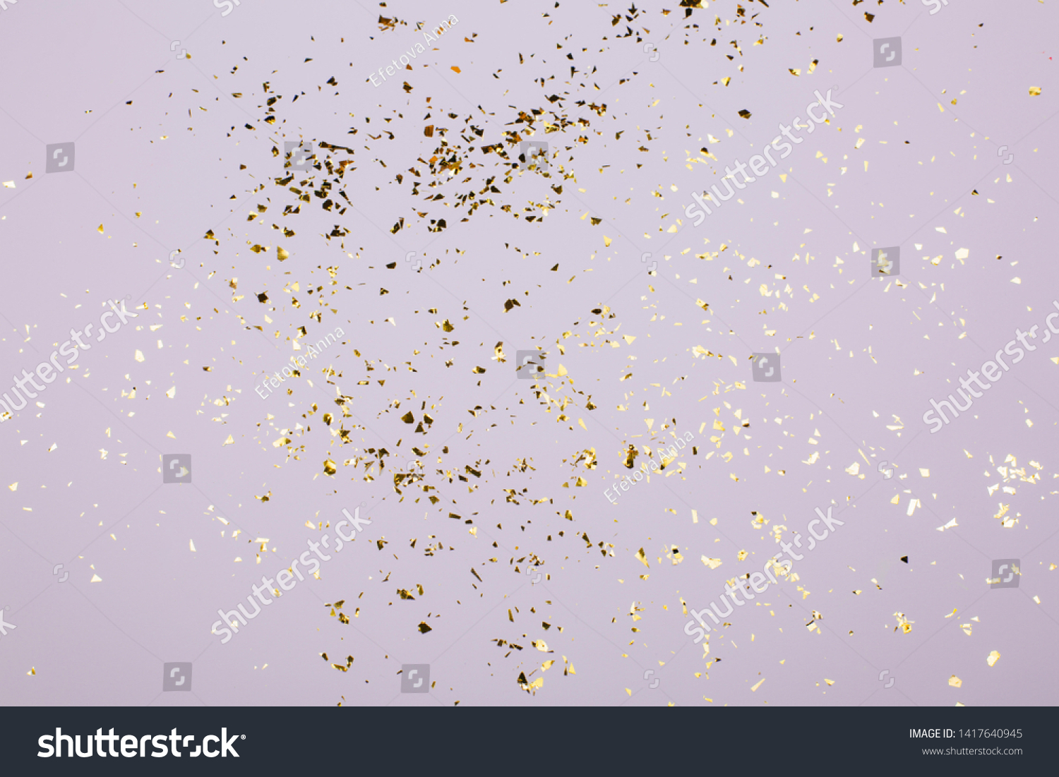 Golden flying sparkles on grey holiday background. Festive backdrop for your projects. #1417640945