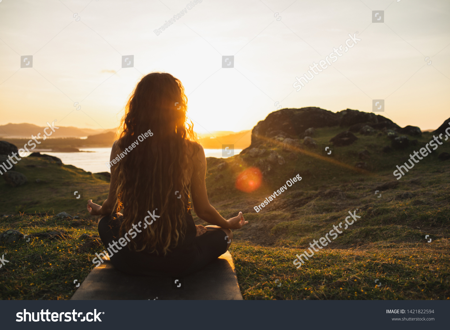 Woman meditating yoga alone at sunrise mountains. View from behind. Travel Lifestyle spiritual relaxation concept. Harmony with nature. #1421822594