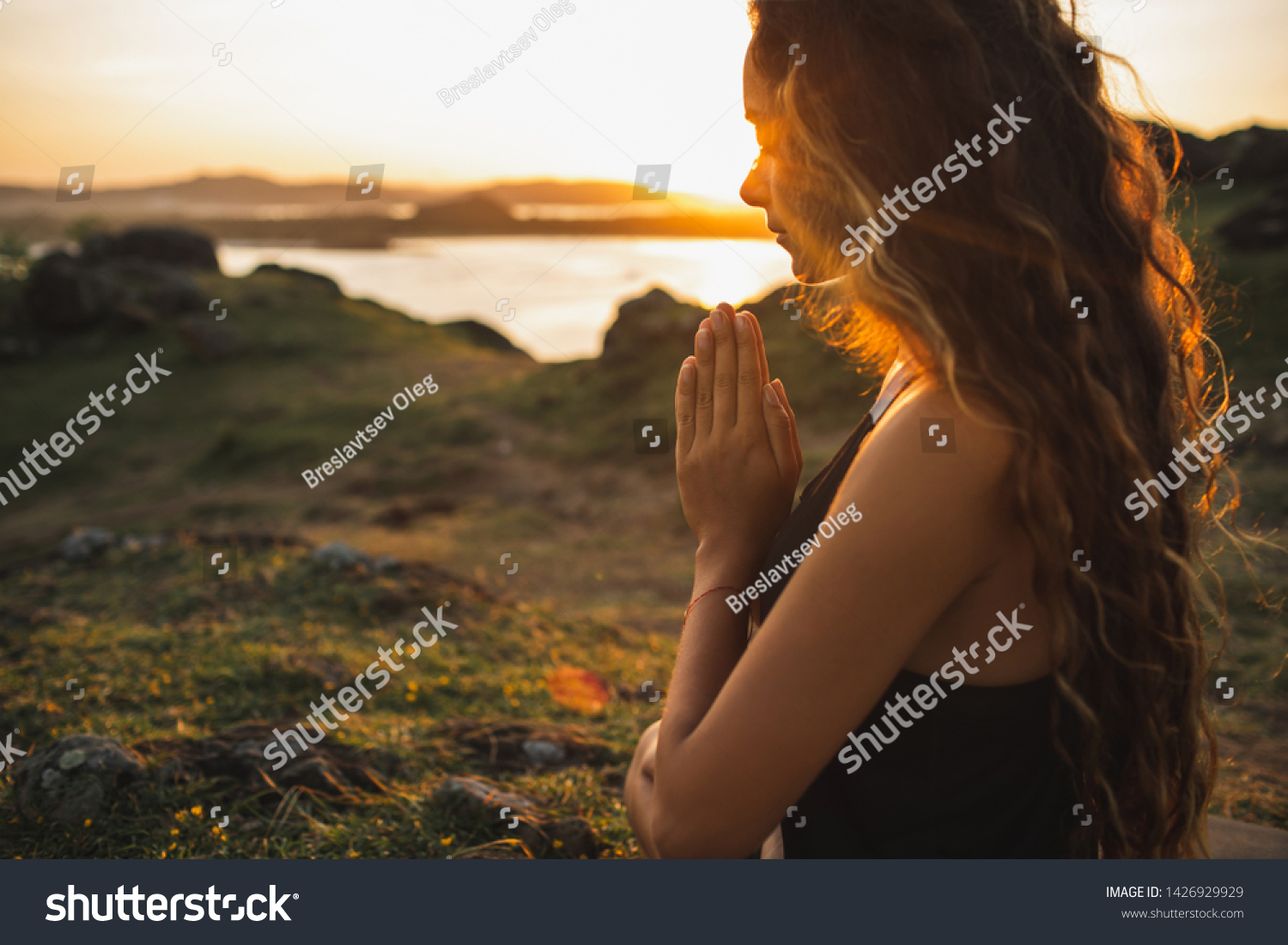 Woman praying alone at sunrise. Nature background. Spiritual and emotional concept. Sensitivity to nature #1426929929
