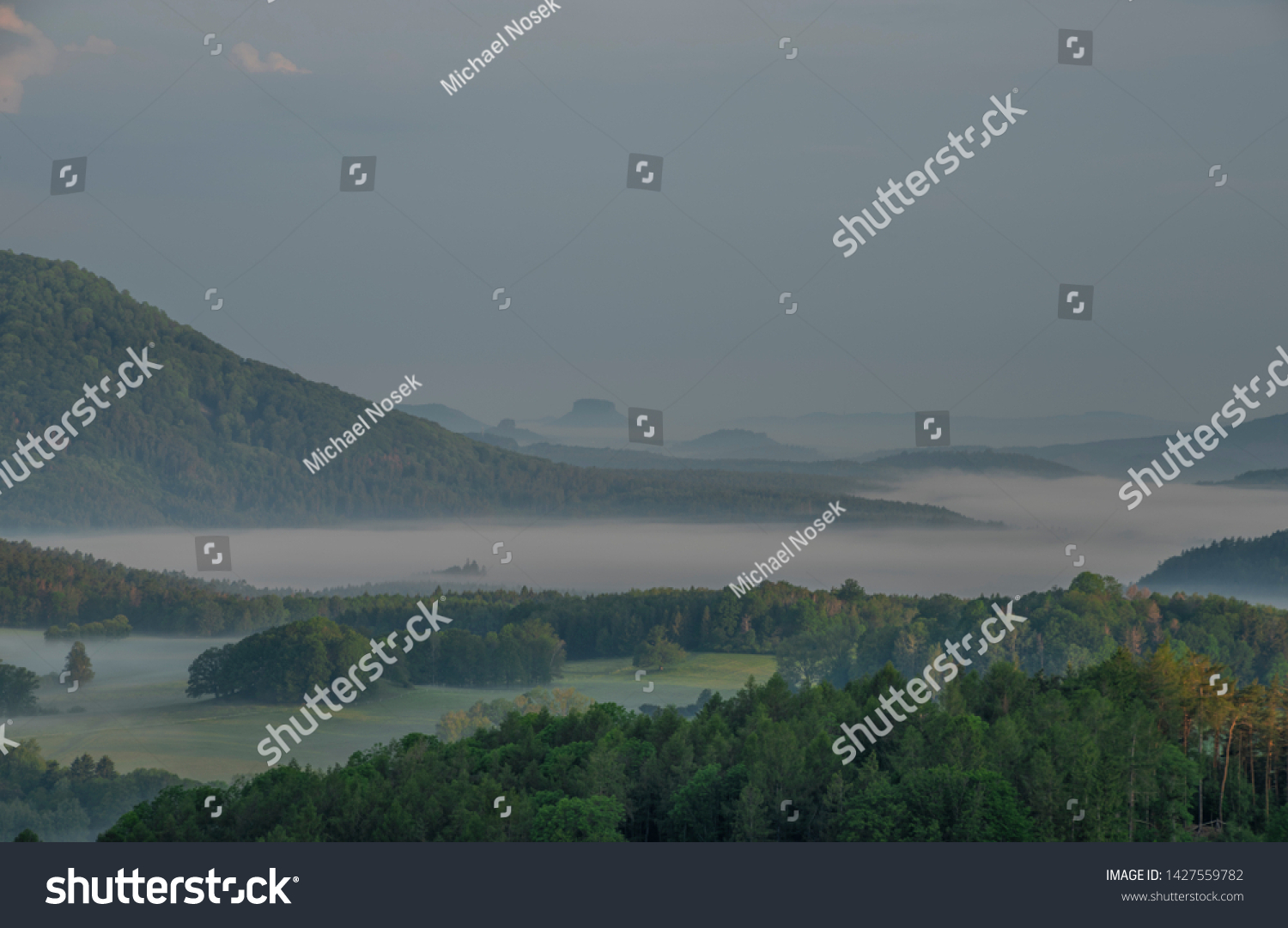 View from Jehla hill over Ceska Kamenice town in spring misty morning in national park #1427559782