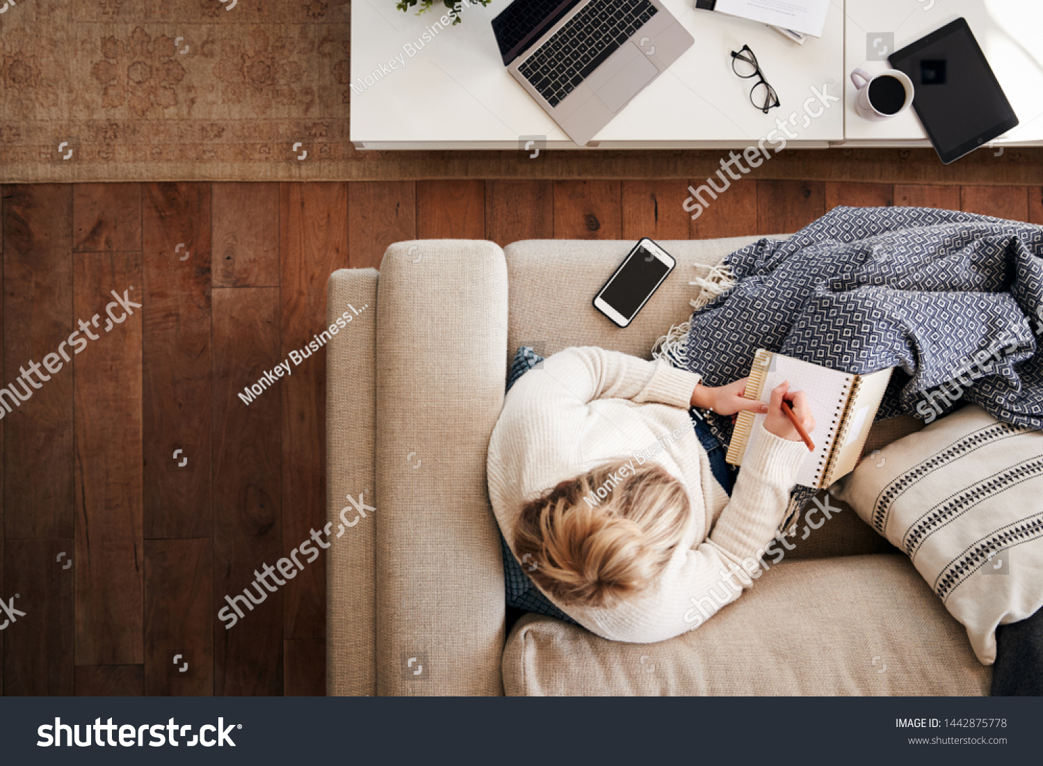 Overhead Shot Looking Down On Woman Working As Social Media Influencer At Home Lying On Sofa #1442875778
