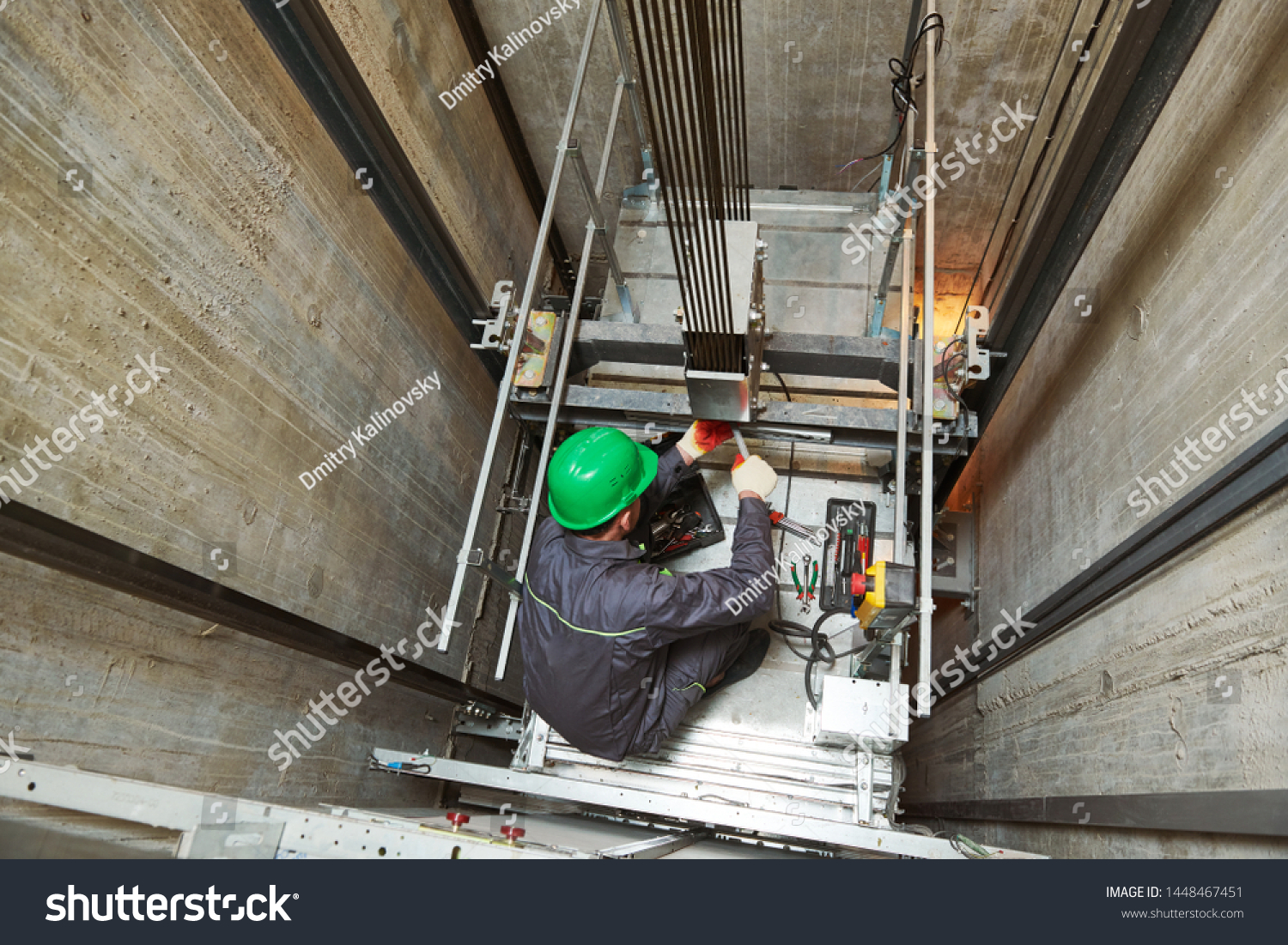 lift machinist repairing elevator in lift shaft #1448467451