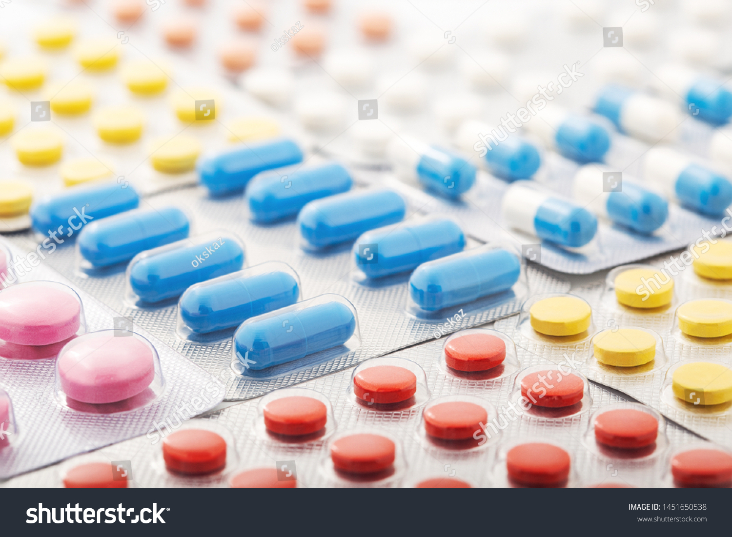 Heap of medical pills in white, blue and other colors. Pills in plastic package. Concept of healthcare and medicine. #1451650538