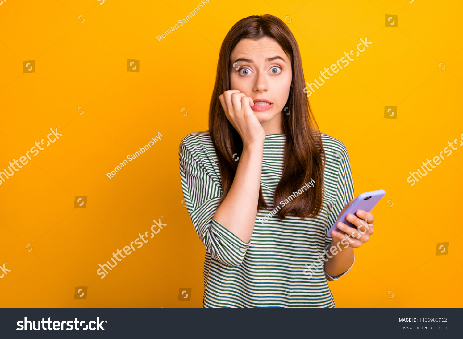Photo of worried concerned girlfriend seeing her phone screen cracked and shattered to pieces while isolated with yellow background #1456986962