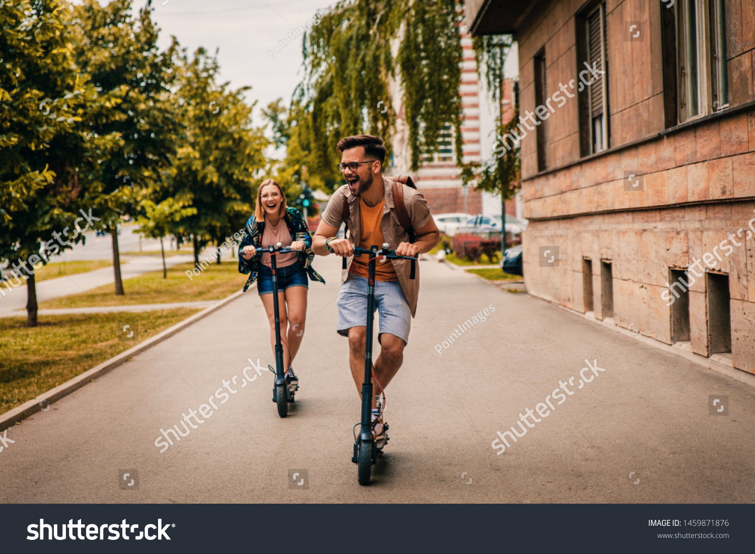 Young couple on vacation having fun driving electric scooter through the city. #1459871876