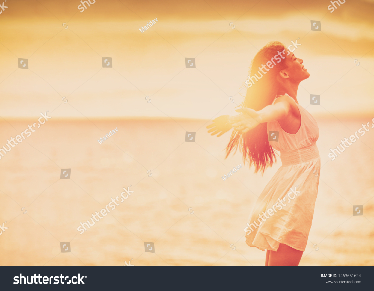 Wellness woman feeling free with open arms in freedom side profile silhouette on ocean beach background. Stress free happy emotion people. #1463651624