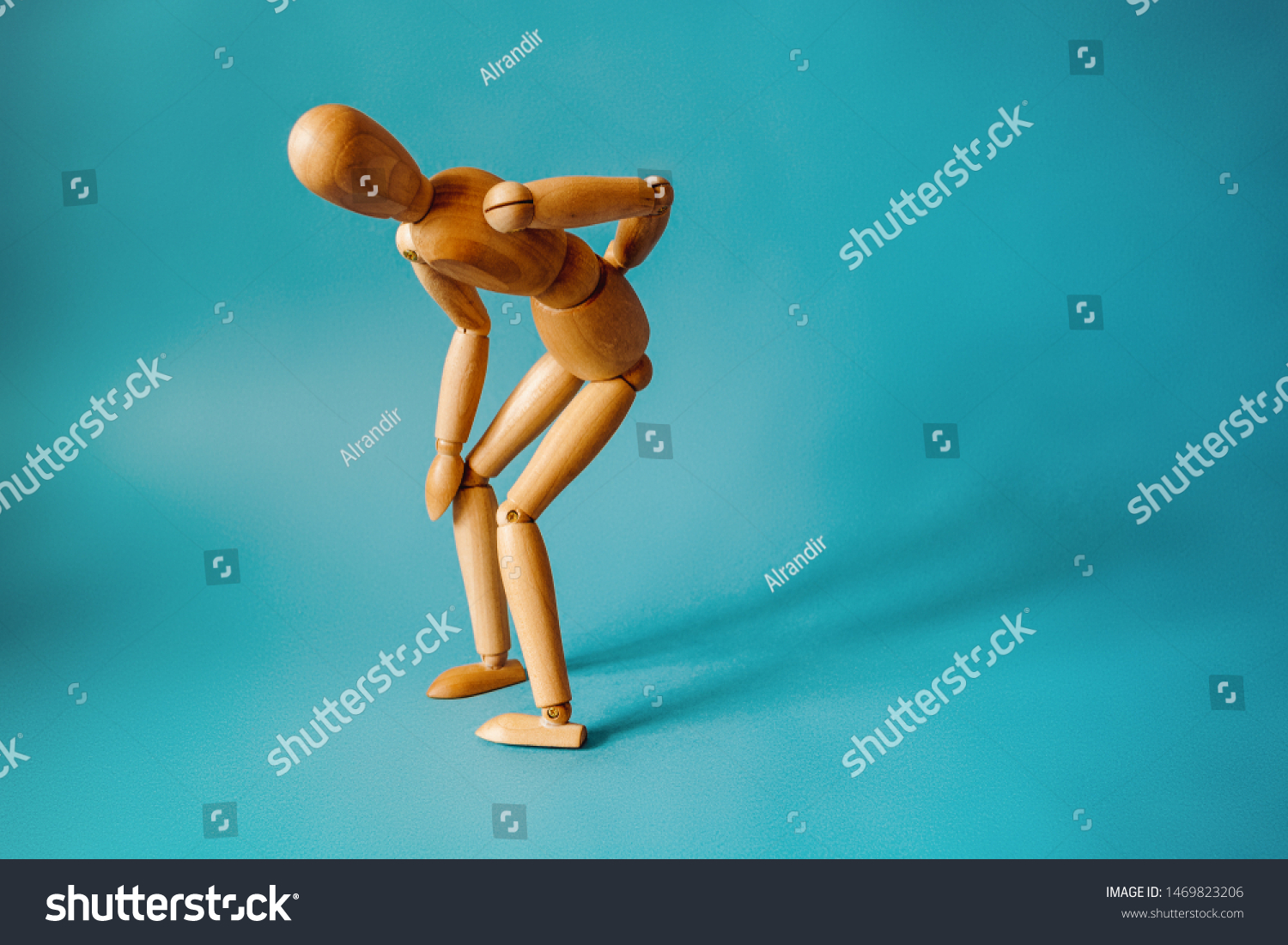 Concept of back pain. A wooden figure depicts a pain in the back. #1469823206