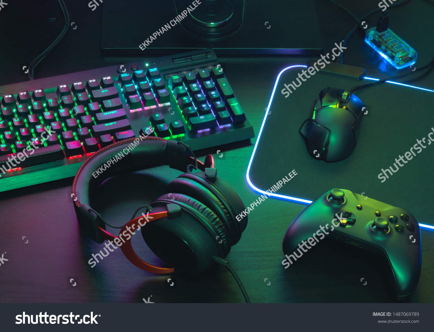 gamer work space concept, top view a gaming gear, mouse, keyboard, joystick, headset, mobile joystick, in ear headphone and mouse pad with rgb color on black table background. #1487069789