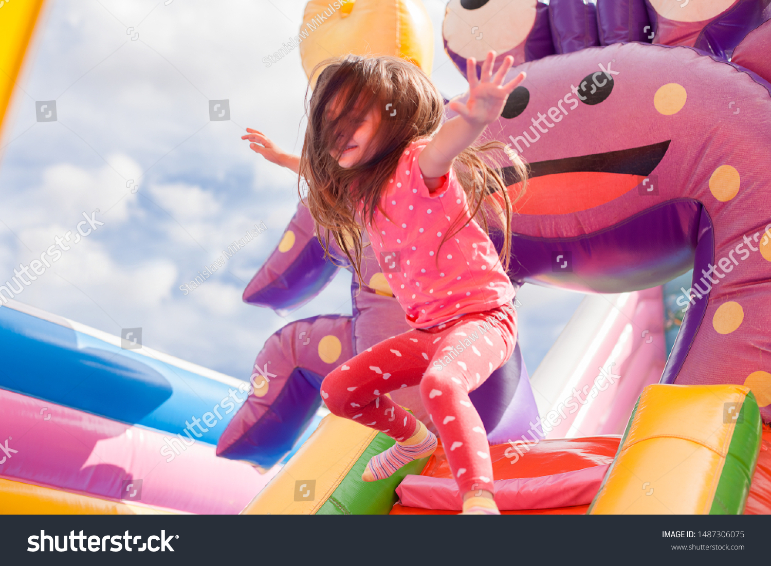 A cheerful child plays in an inflatable castle #1487306075