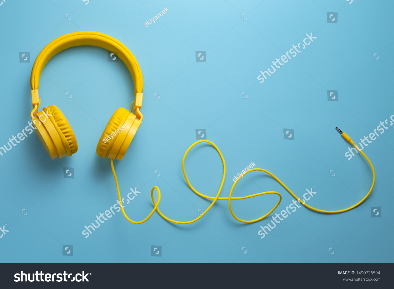 Yellow headphones on blue background. Music concept. #1490726594