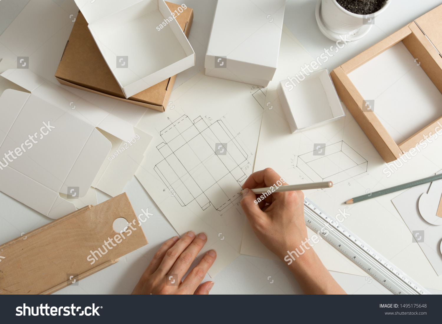 Designer draws a mockup for crafting eco cardboard box. Development a sketch of paper packaging. #1495175648