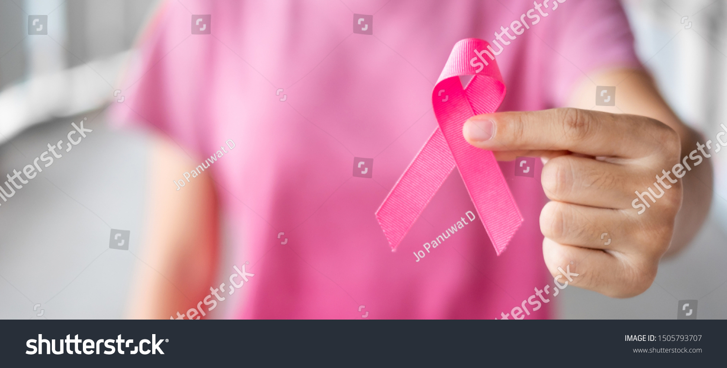 October Breast Cancer Awareness month, Woman in pink T- shirt with hand holding Pink Ribbon for supporting people living and illness. Healthcare, International Women day and World cancer day concept #1505793707