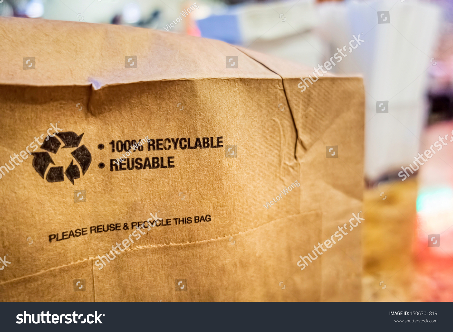 Brown paper bag that is 100% recyclable and reusable on a counter. A printed plea for user to recycle and reuse this bag as a form of packaging. #1506701819