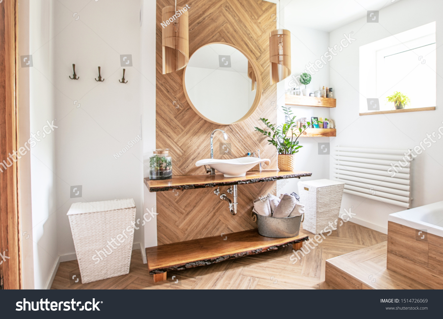 White sink on wood counter with a round mirror hanging above it. Bathroom interior. #1514726069