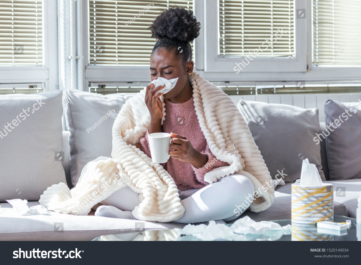 Sick day at home. African American woman has runny nose and common cold. Cough. Closeup Of Beautiful Young Woman Caught Cold Or Flu Illness. Portrait Of Unhealthy Girl Drinking Tea. #1520149034