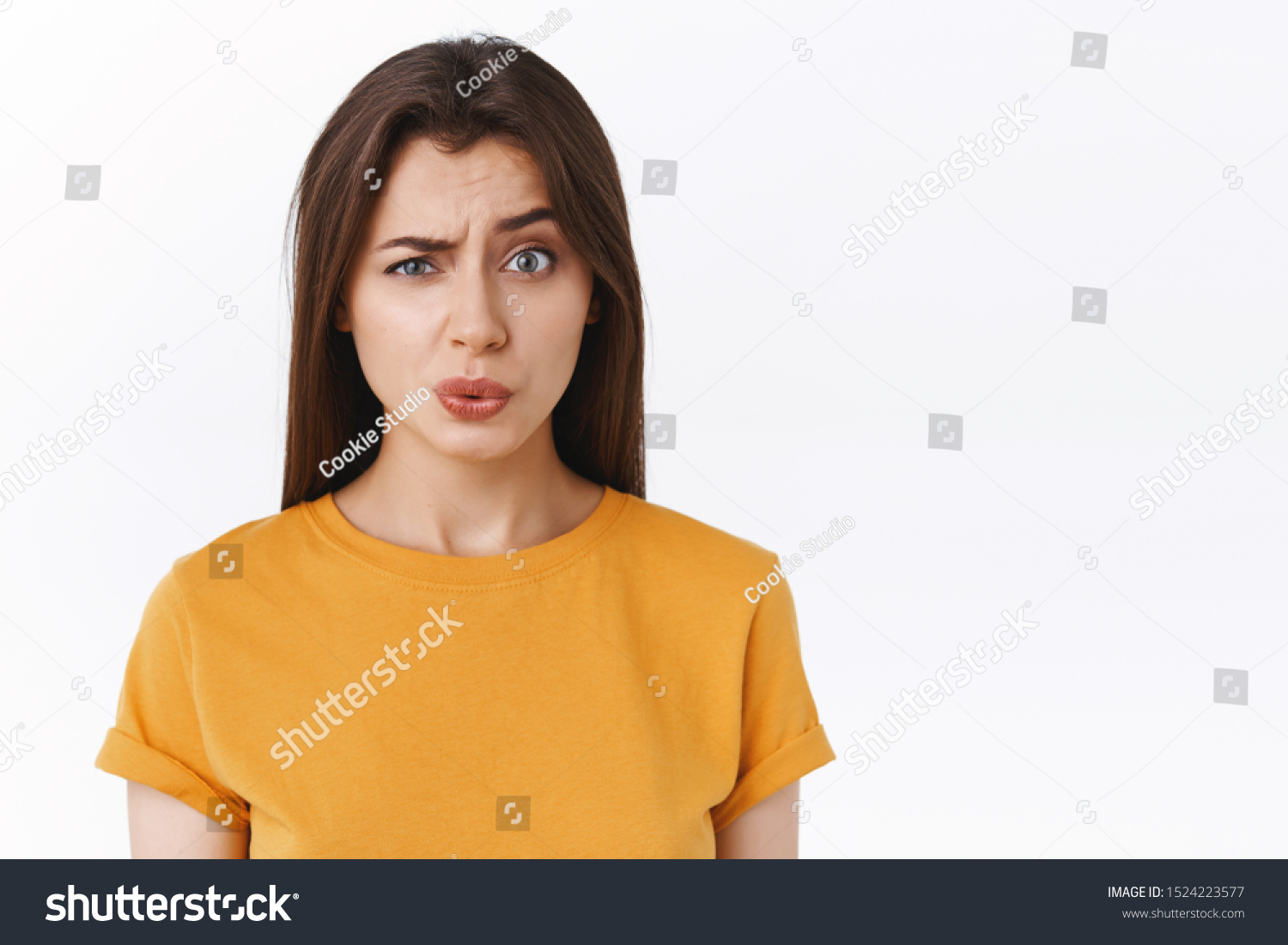 Ouch it probably hurts. Pity good-looking modern brunette woman in yellow t-shirt cringe and grimace as seeing someone got punched in face, folding lips and look uneasy camera, white background #1524223577