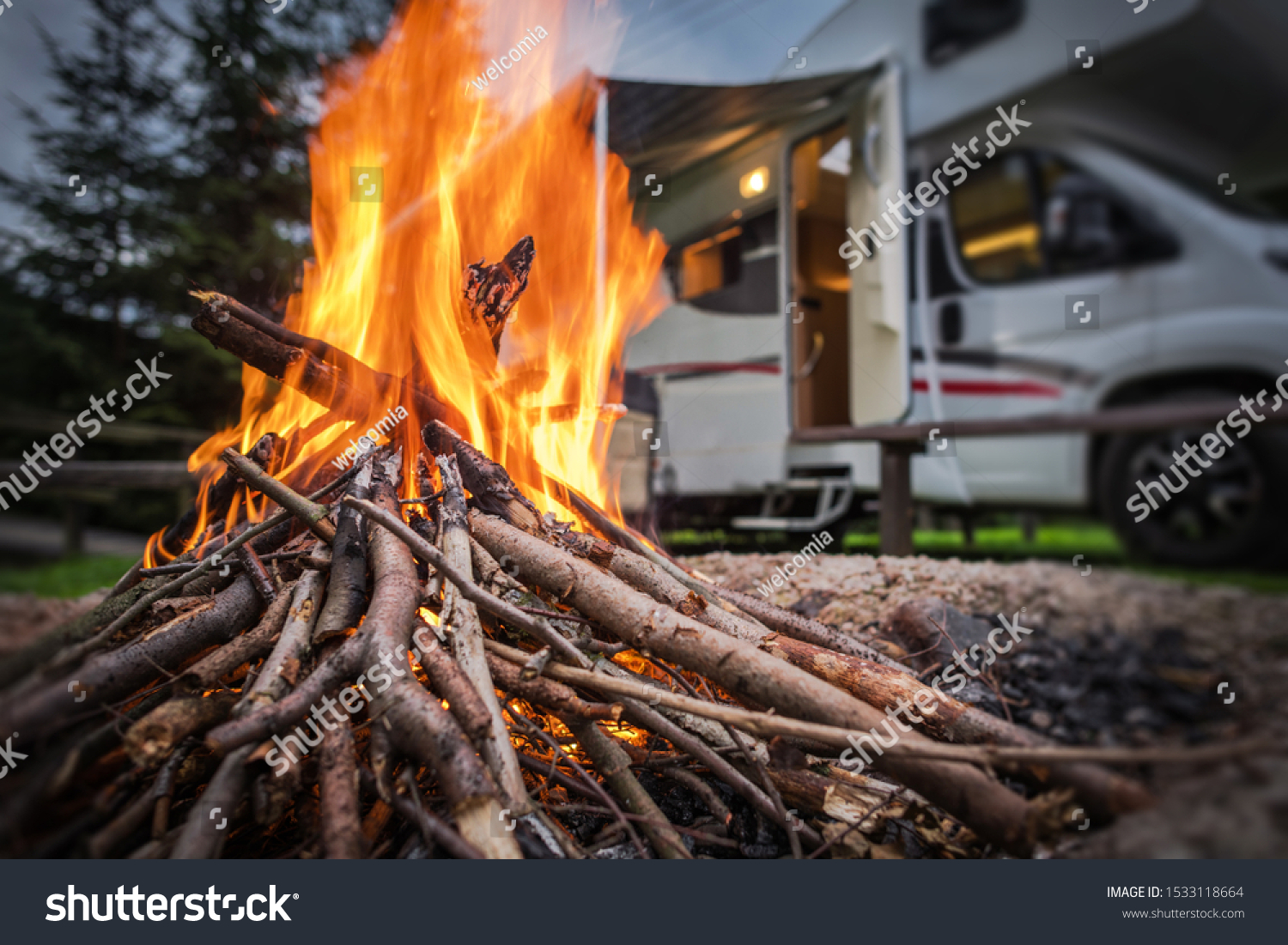 RV Park Campfire in Front of Motorhome Pitch. Summer Camping with Motorhome. #1533118664