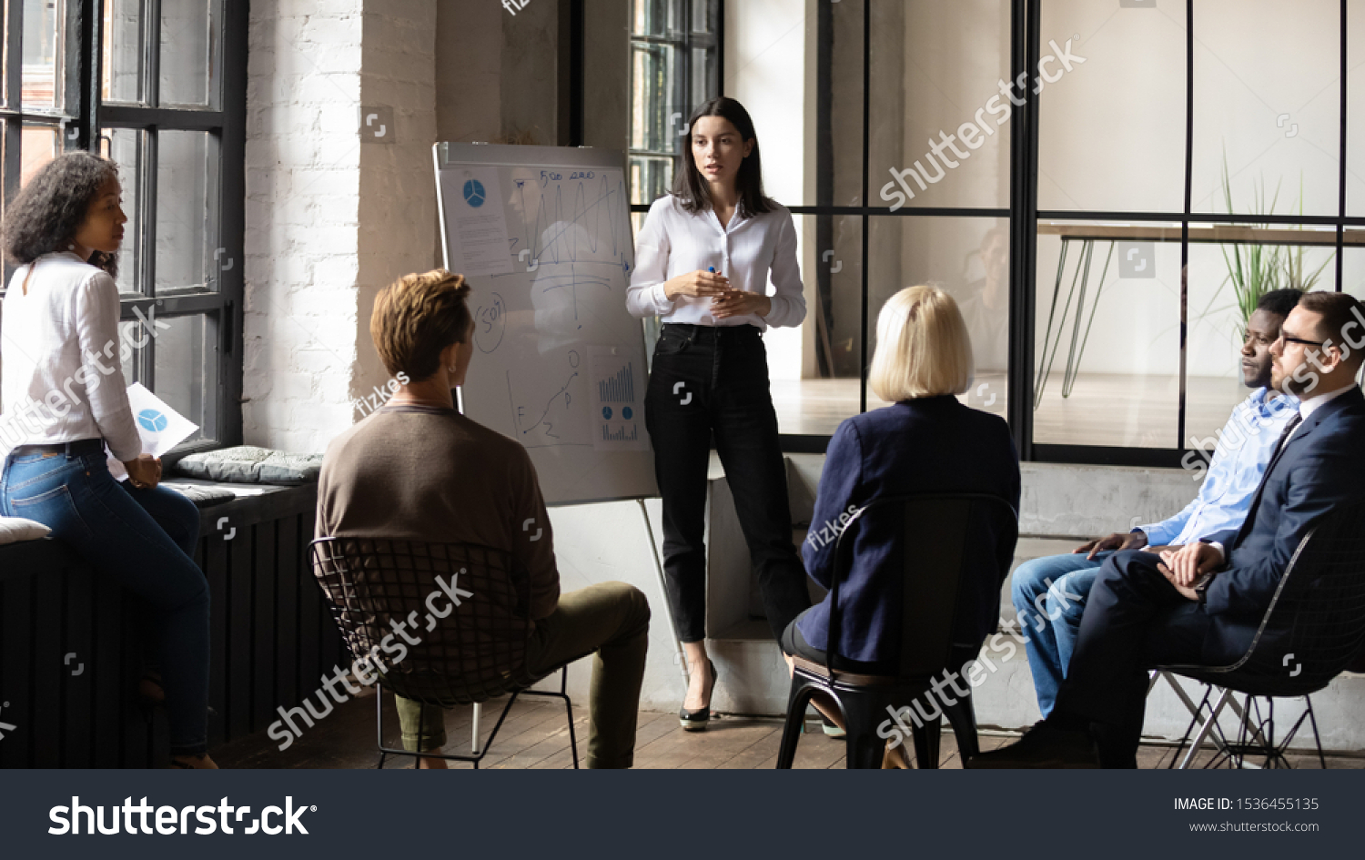 Confident lady business trainer coach leader give flip chart presentation consulting clients teaching employees training team people speaking explaining strategy at marketing workshop concept #1536455135
