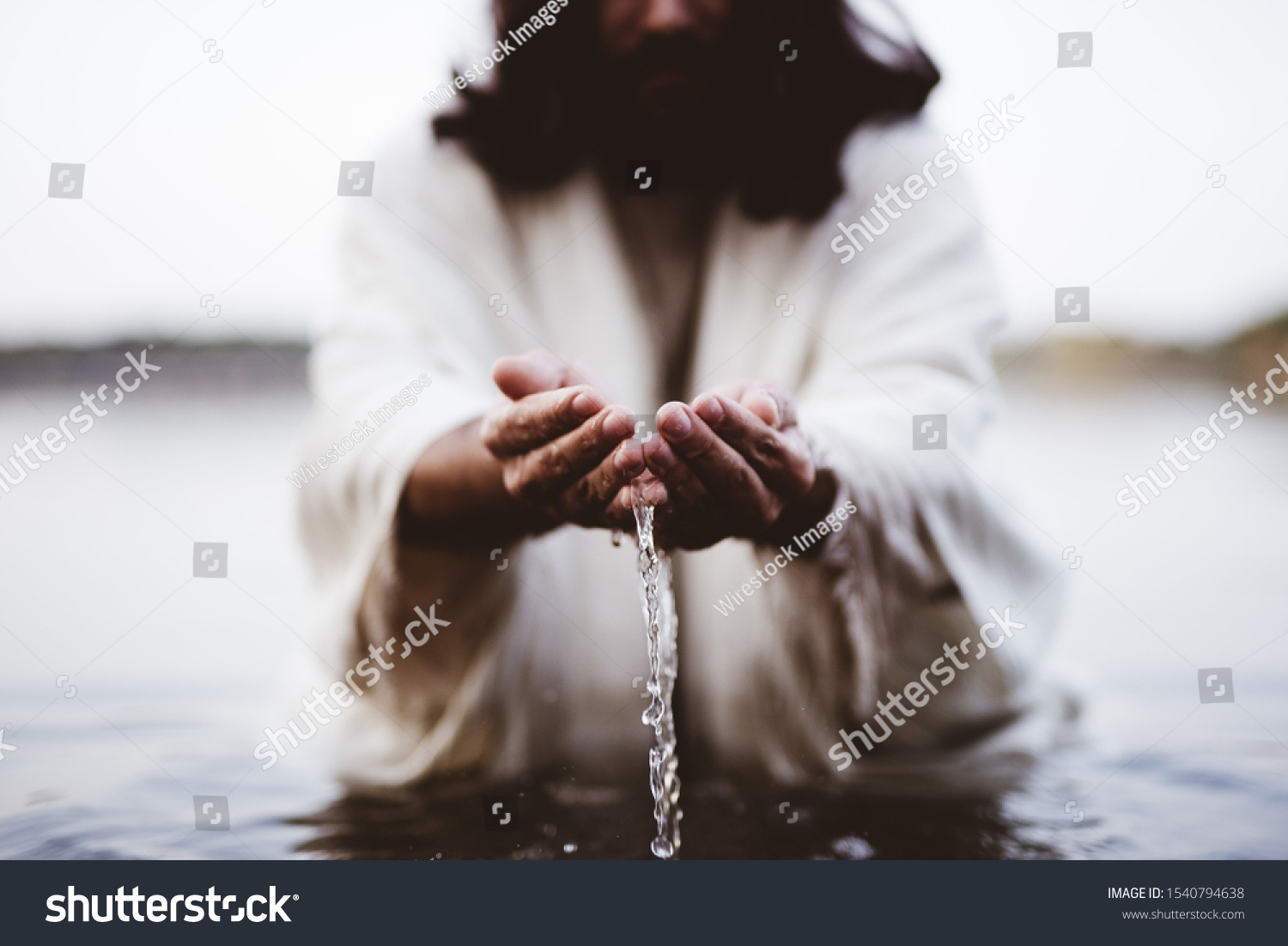A closeup shot of Jesus Christ holding water with his palms #1540794638