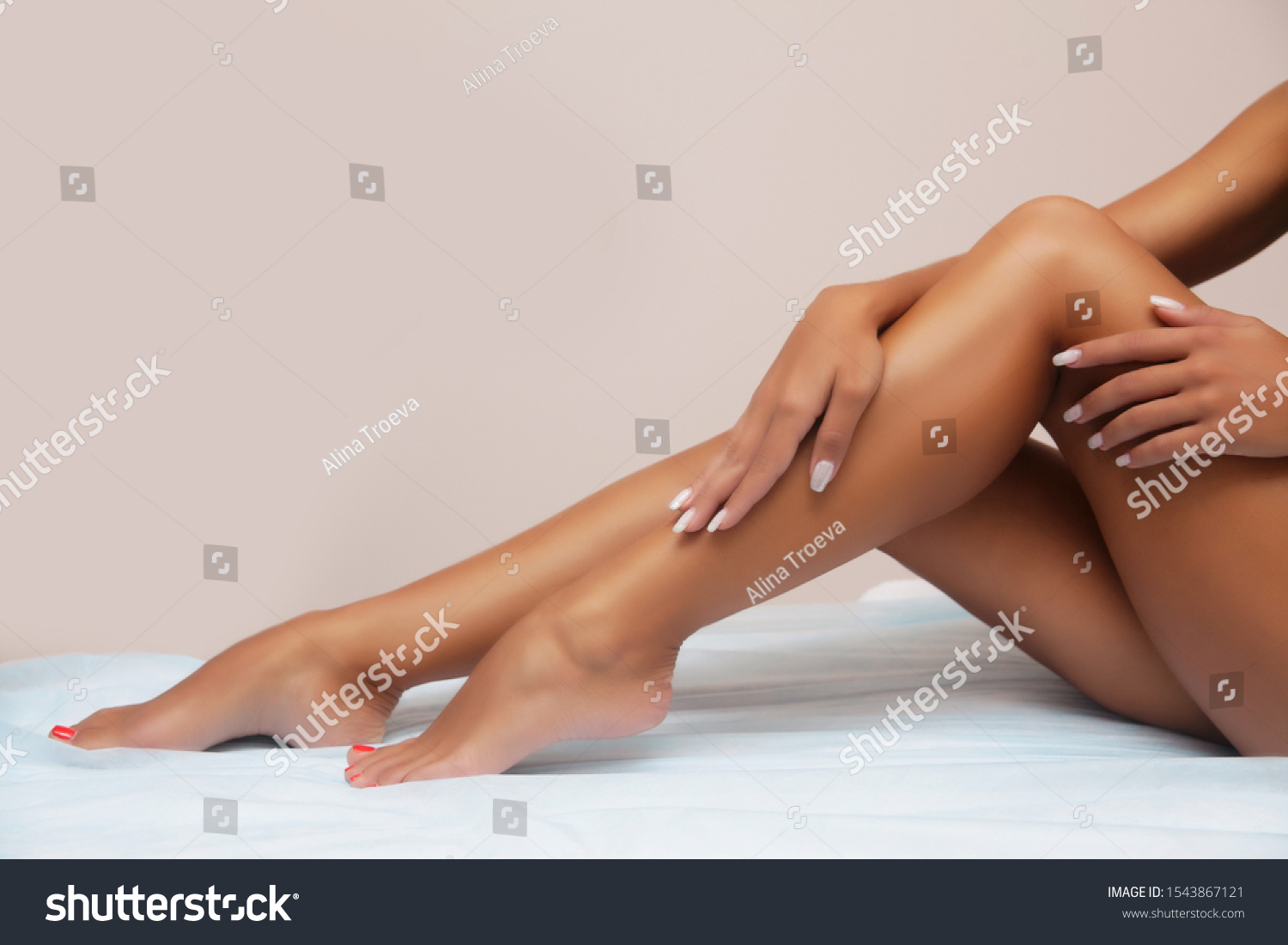 Woman body care. Close up of long female tanned legs with perfect smooth soft skin, pedicure, healthy nails on white background. Epilation, beauty and health concept
 #1543867121