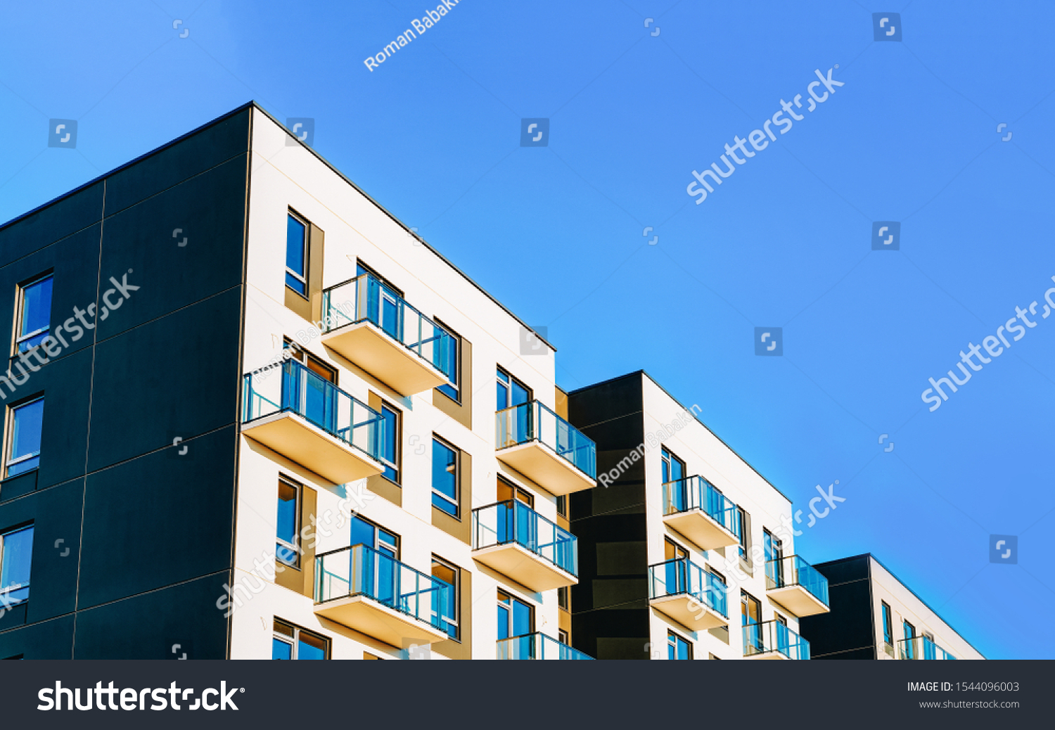 Fragment of Modern residential apartment with flat buildings exterior. Detail of New luxury house and home complex. Part of City Real estate property and condo architecture. Copy space. Blue sky #1544096003
