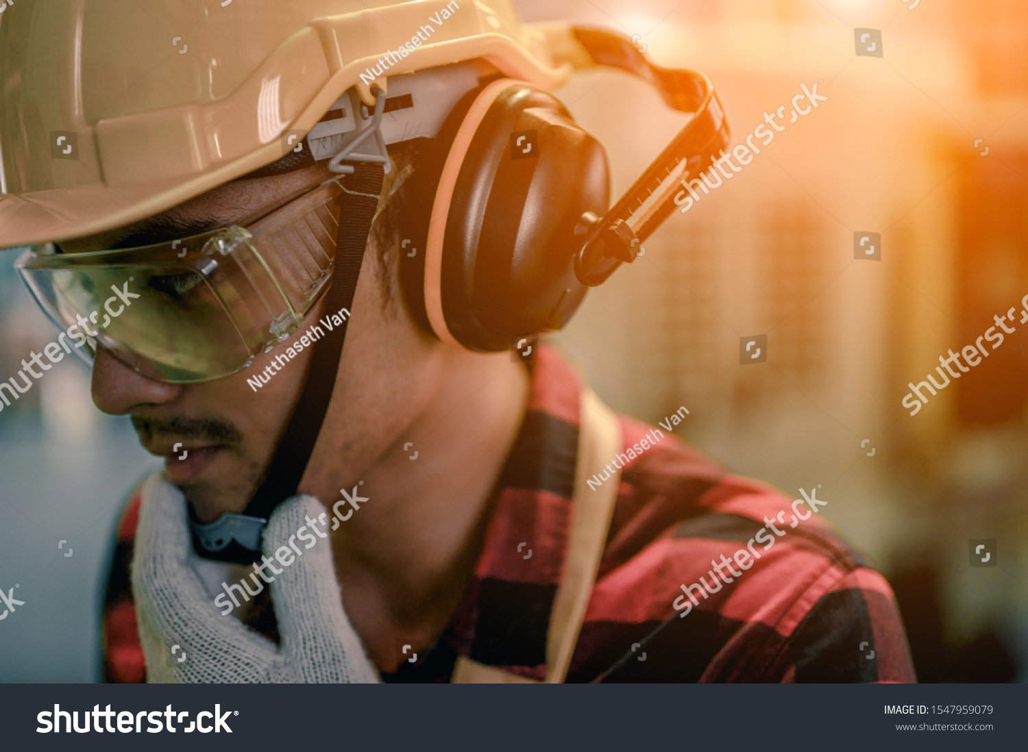 Close-up a young engineer wearing a safety helmet Glasses and earphones are prepared to be working that require high safety for his own safety at industrial plants. #1547959079