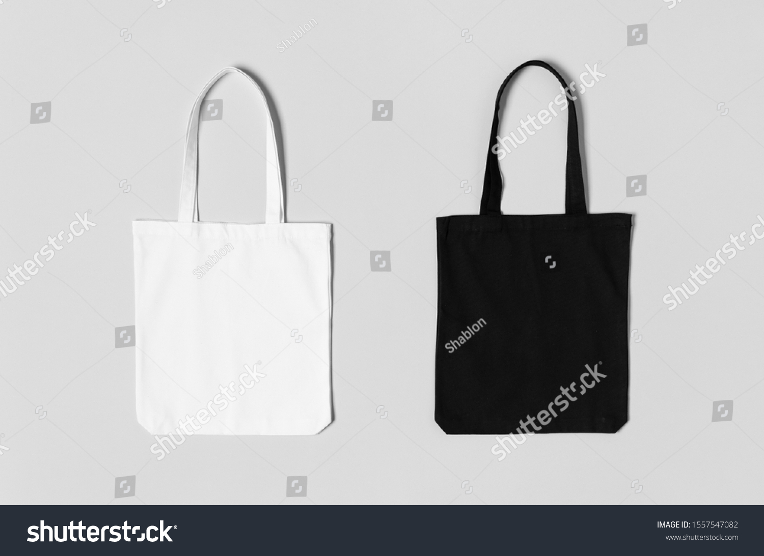 White and black tote bags mockup on a grey background. #1557547082