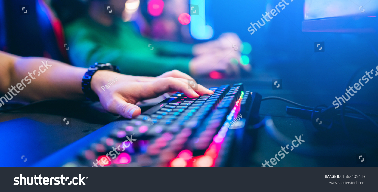 Professional cyber video gamer studio room with personal computer armchair, keyboard for stream in neon color blur background. Soft focus. #1562405443