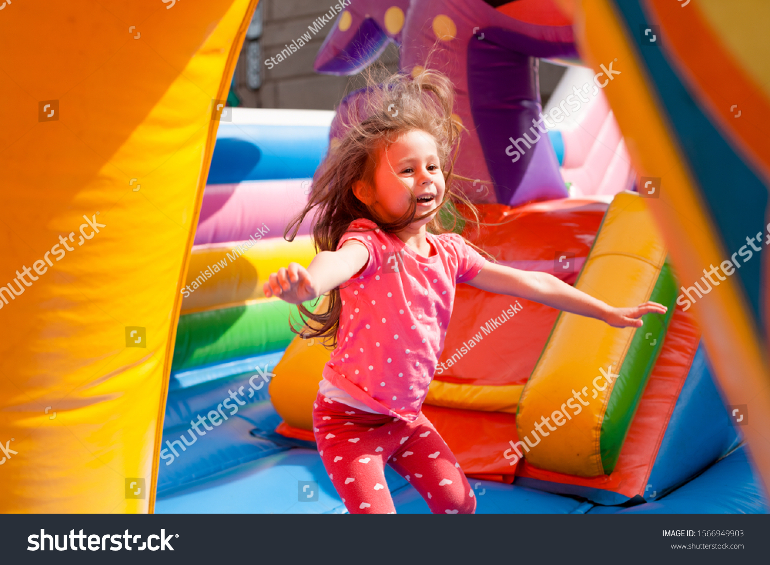 A cheerful child plays in an inflatable castle #1566949903