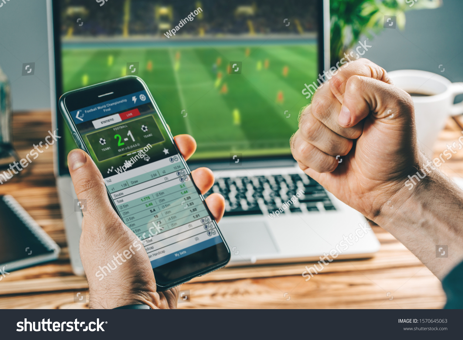 Man watching football play online broadcast on his laptop, cheering for his favourite team, making bets at bookmaker's website. #1570645063