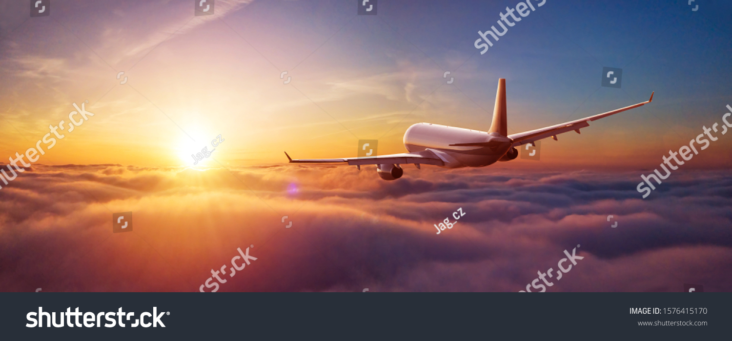 Passengers commercial airplane flying above clouds in sunset light. Concept of fast travel, holidays and business. #1576415170