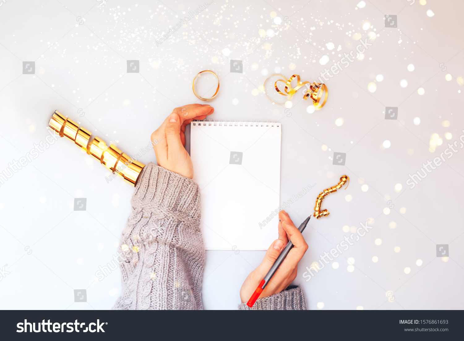 Woman hands holding clear white notebook, golden sparkles, new year, flat lay. #1576861693